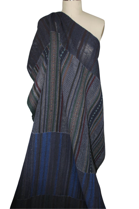 A dark navy blue patchwork fabric with vertical striped patterns in blue, green, and red.