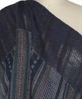 A dark navy blue patchwork fabric with vertical striped patterns in blue, green, and red.