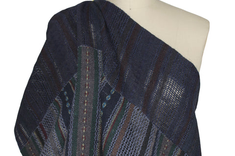 A dark navy blue patchwork fabric with vertical striped patterns in blue, green, and red.