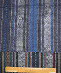 A dark navy blue patchwork fabric with vertical striped patterns in blue, green, and red.