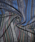 A dark navy blue patchwork fabric with vertical striped patterns in blue, green, and red.