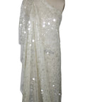 White sequin fabric draped over a mannequin on a white background