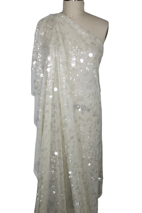 White sequin fabric draped over a mannequin on a white background