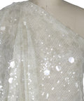White sequin fabric draped over a mannequin on a white background